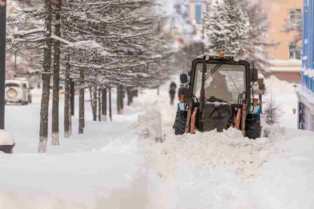 Commercial snow plowing tractor clearing snowy road in Montgomery County, MD | Snow Removal in Montgomery County, MD